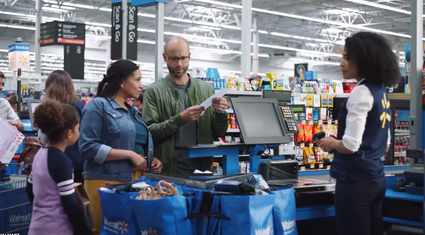 couple checking their receipt in front of a Walmart cashier