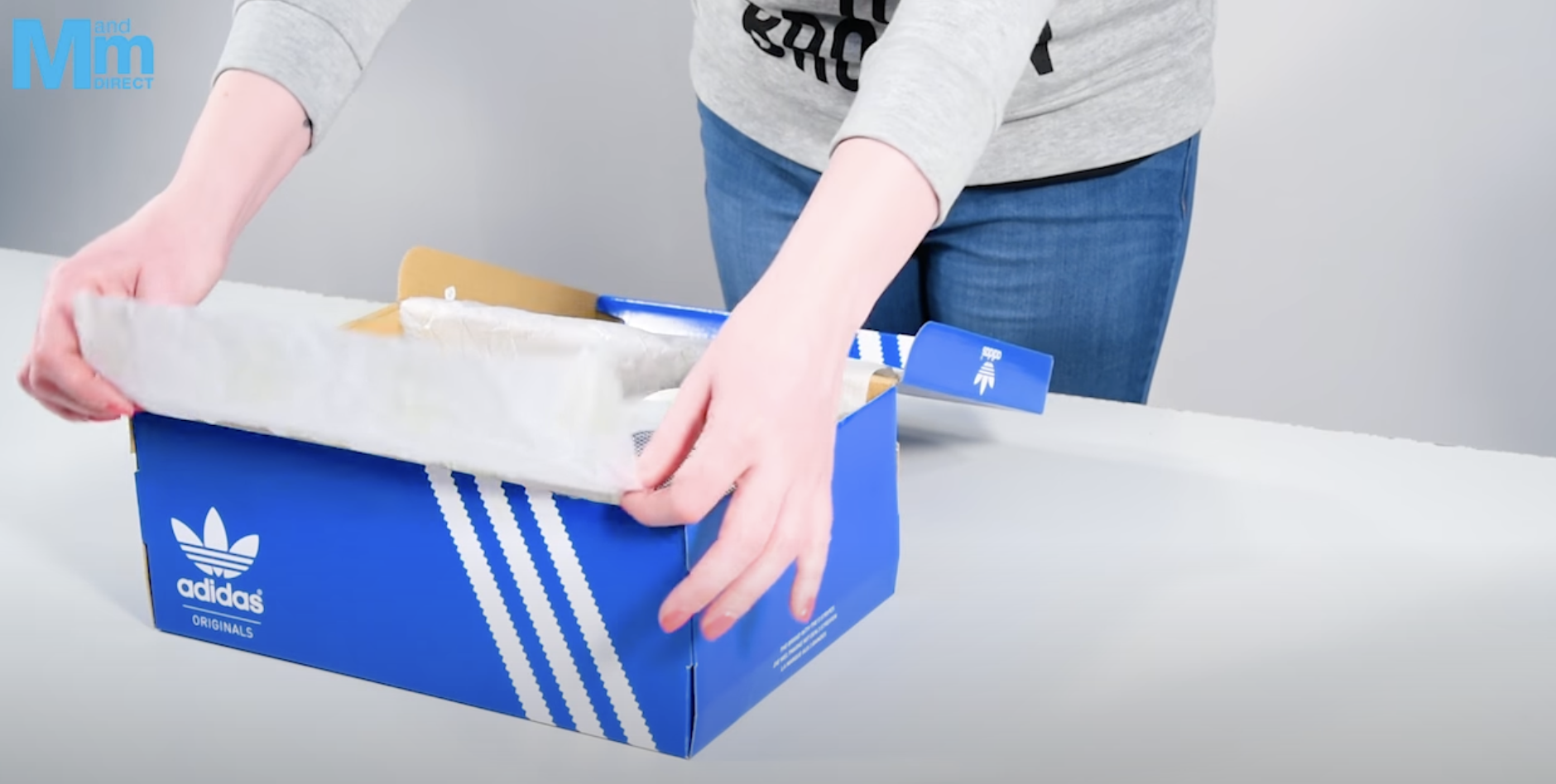 woman opening adidas shoe b...