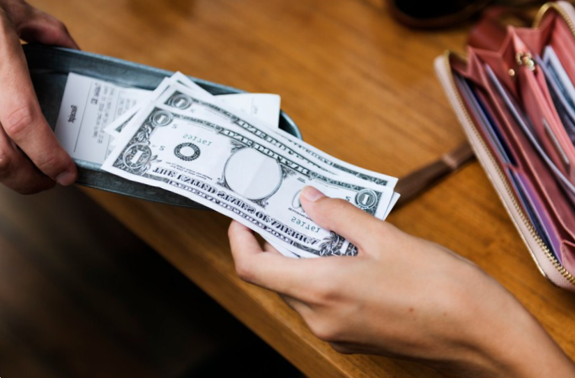 female hands handing cash to male hands close up