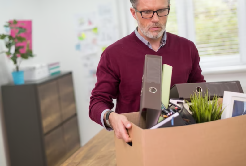 sad man carrying a box with stuff