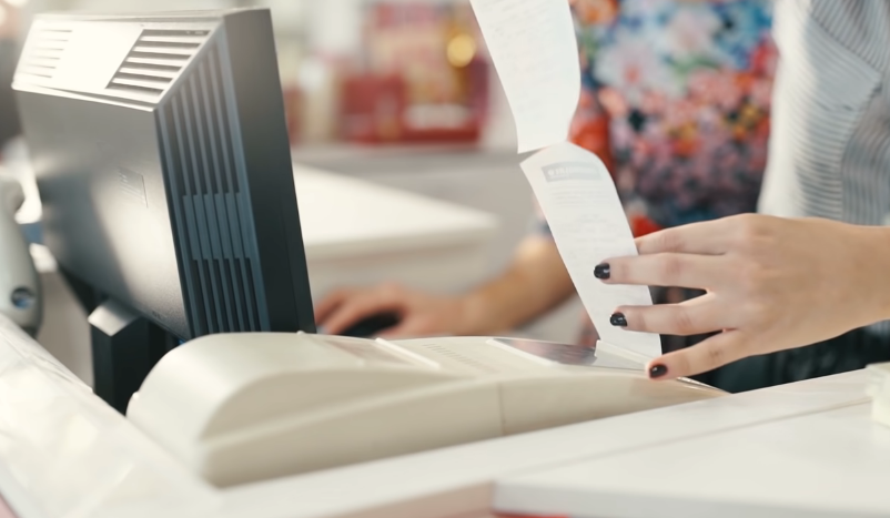 cashier getting a receipt from the printer