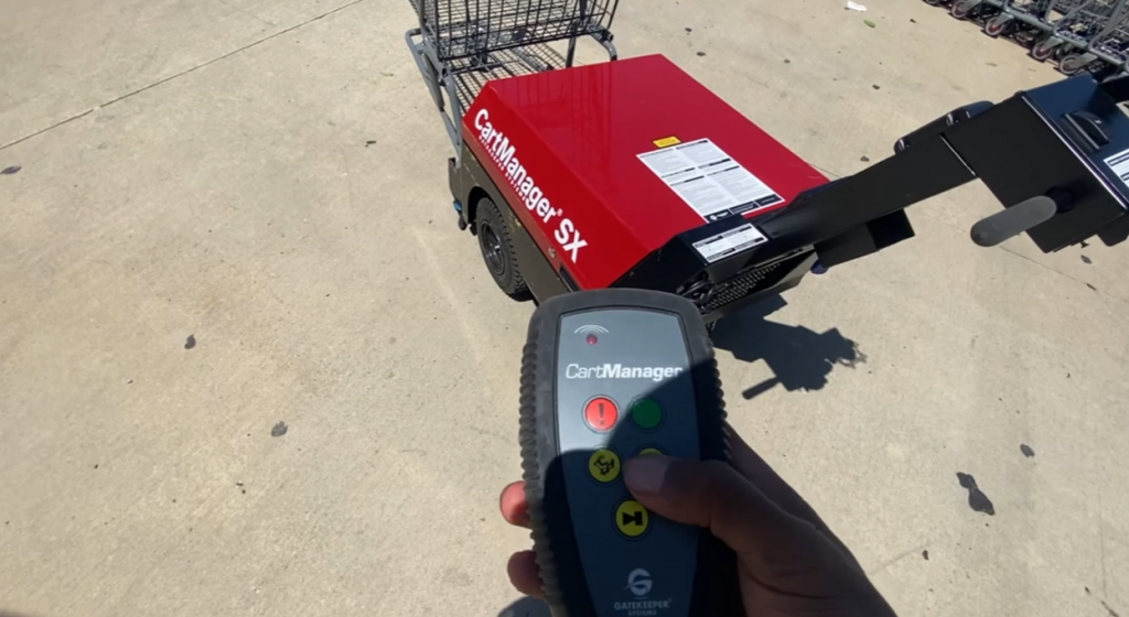 hand holding a  cartManager controller pointing to cart pusher machine