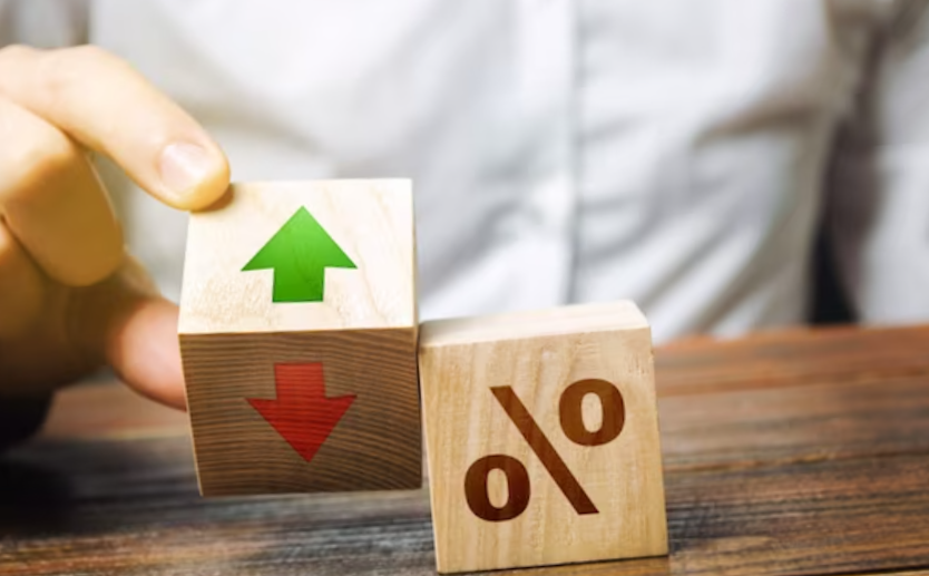 businessman holds wooden blocks with percent and up or down arrow.
