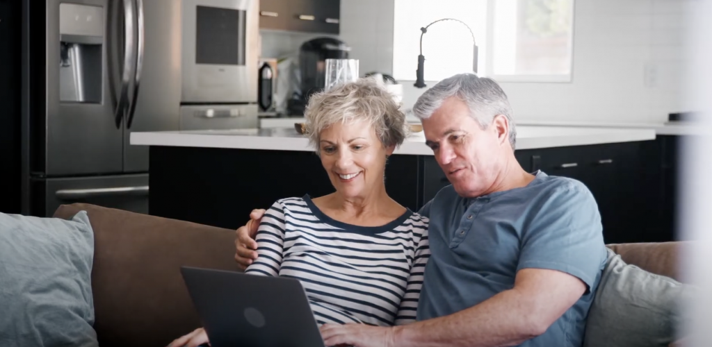 couple sitting in living room using laptop