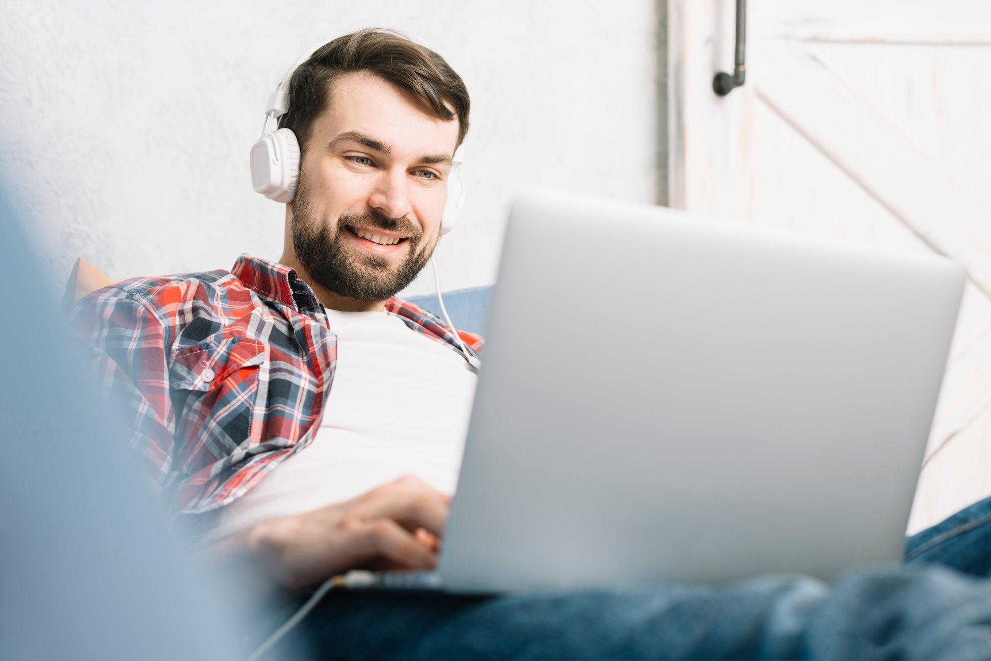 man sitting with headphones in front of a laptop