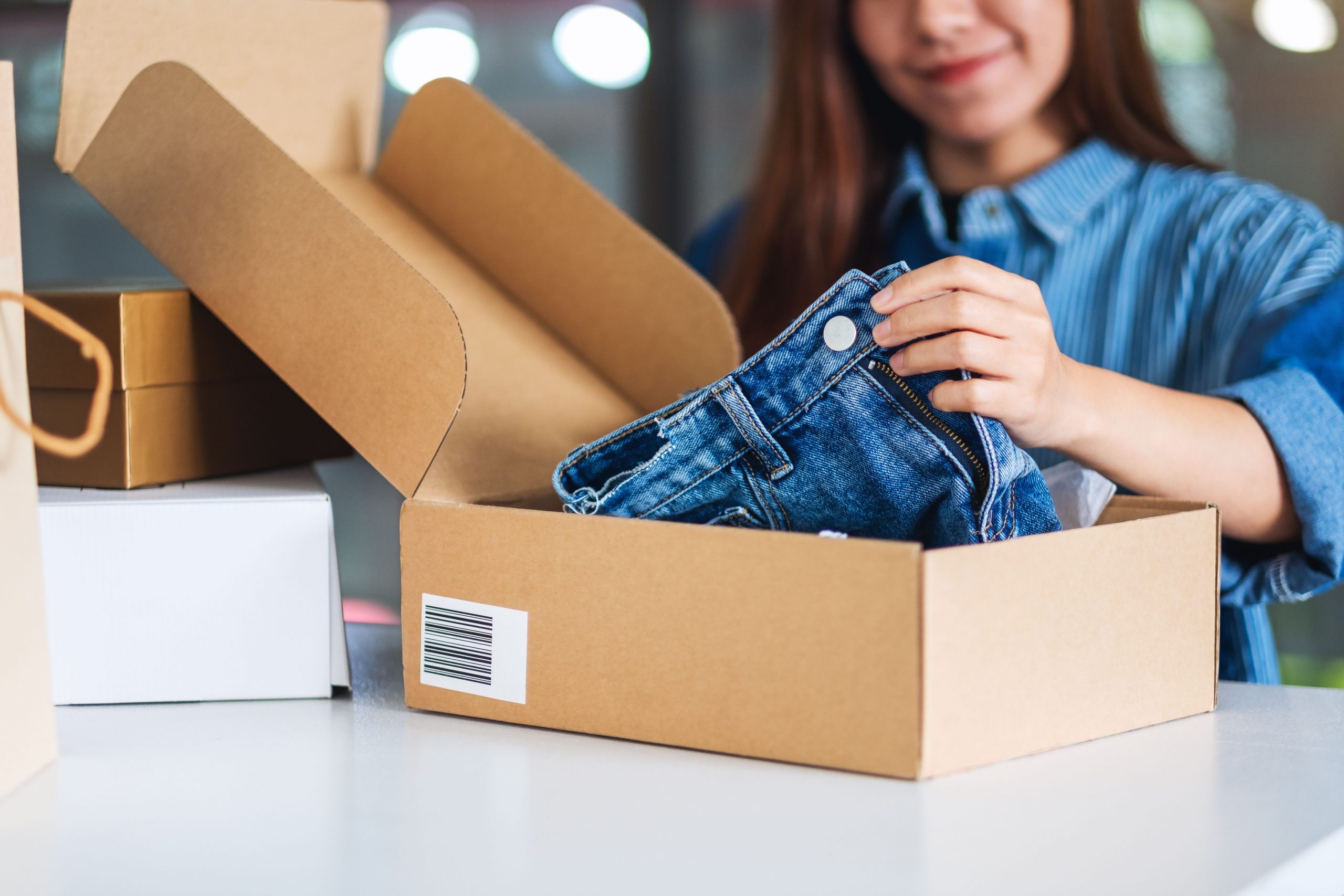 women packing jeans in a box