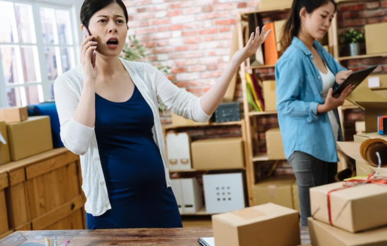 pregnant woman arguing while talking on the phone in warehouse