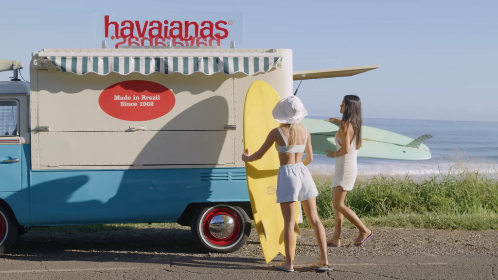 2 women on the beach with a Havaianas van