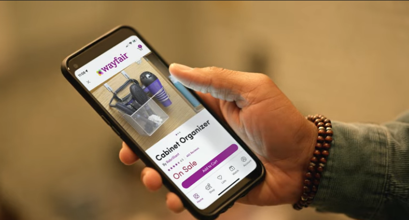 man's hand holding a smartphone in the Wayfair app