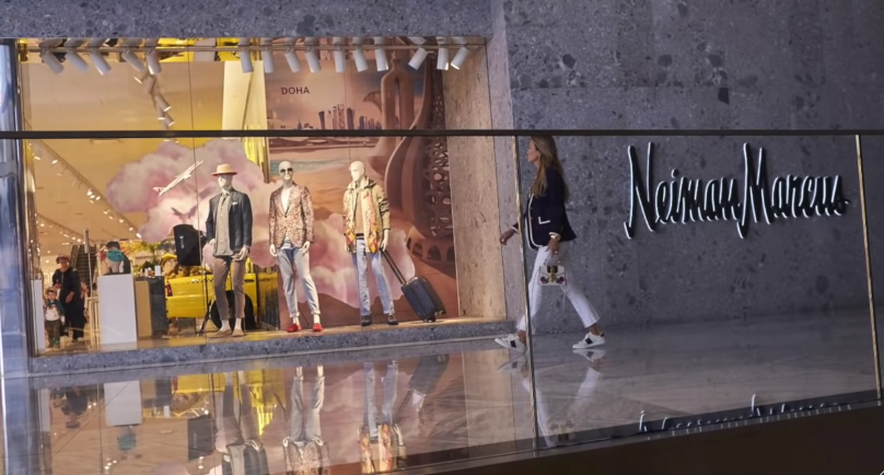 woman walking by a Neiman Marcus store front