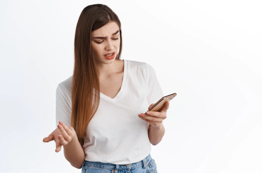 young woman looking confused at mobile screen