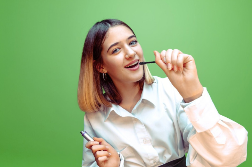 portrait of a girl pretending her mascara is a microphone 