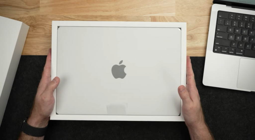 high angle shot of hands holding an apple MacBook box