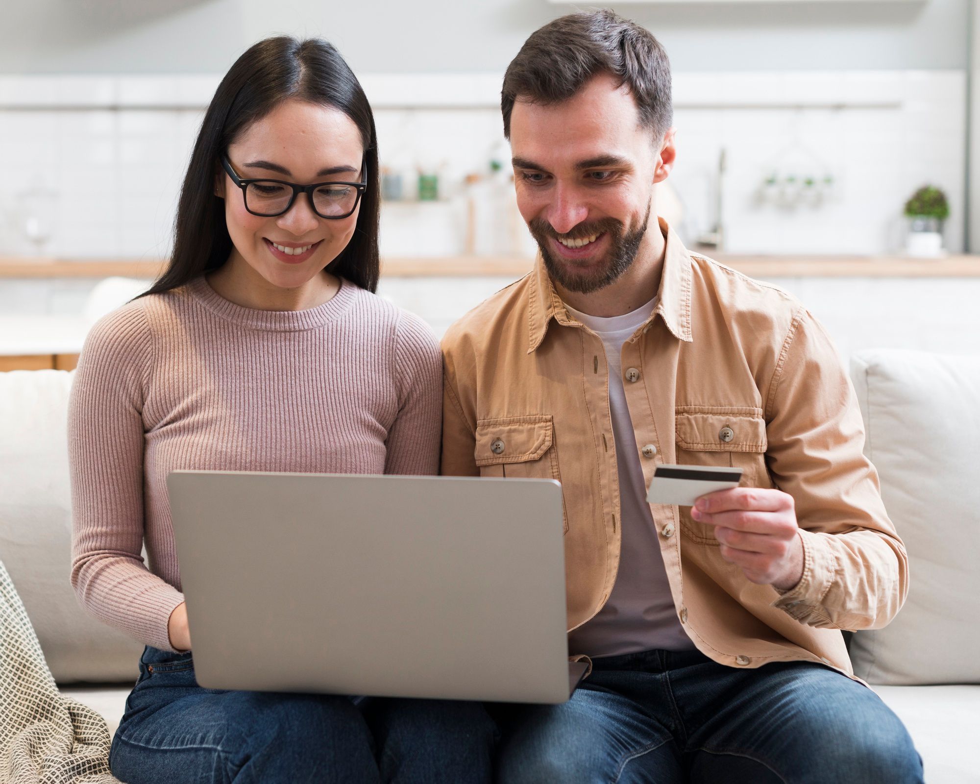 Couple sitting in front of laptop with credit card