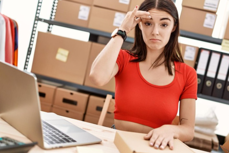 Young hispanic woman preparing order working at storehouse worried and stressed about a problem with hand on forehead nervous and anxious for crisis