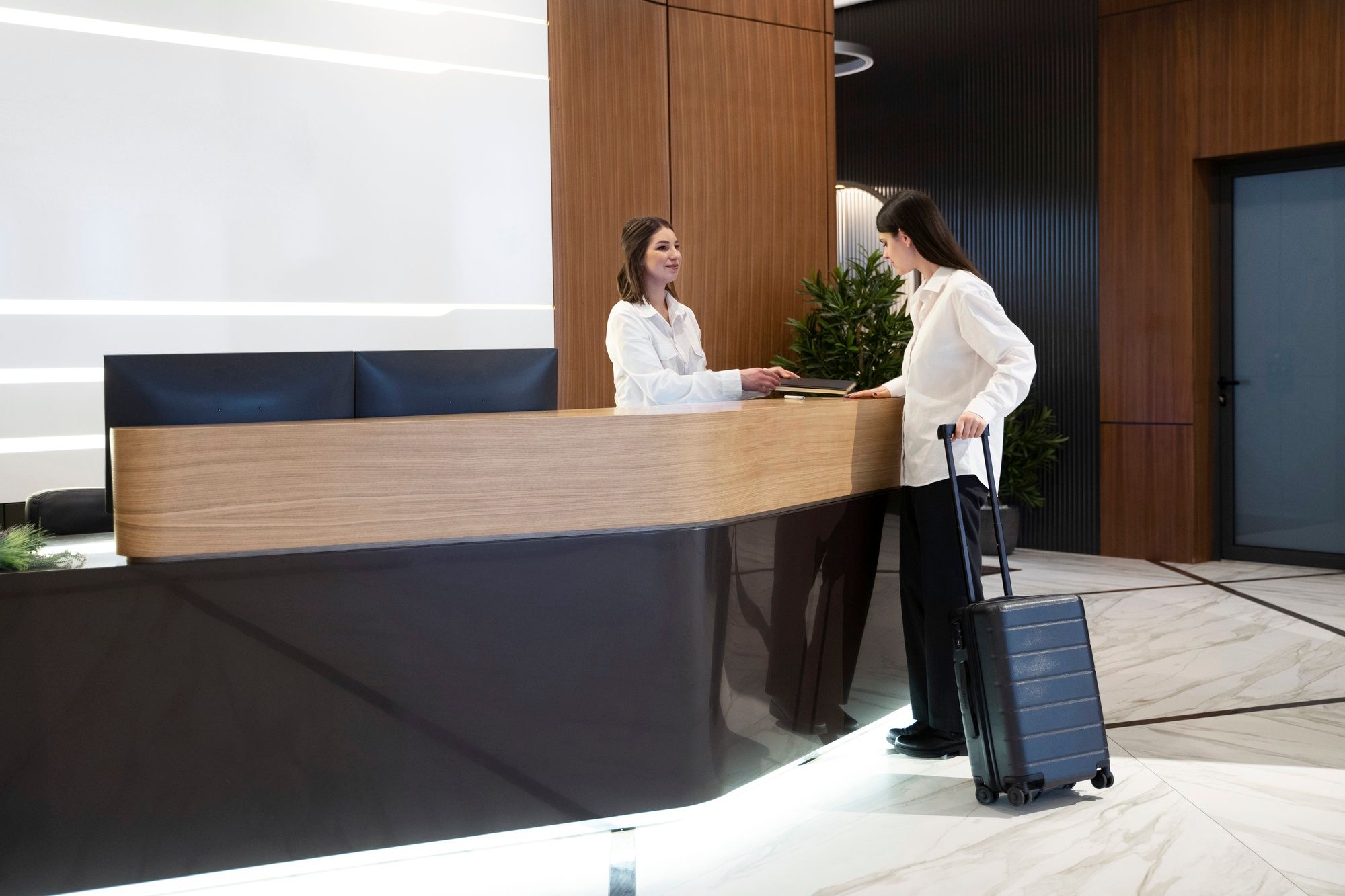 woman checking in at hotel ...