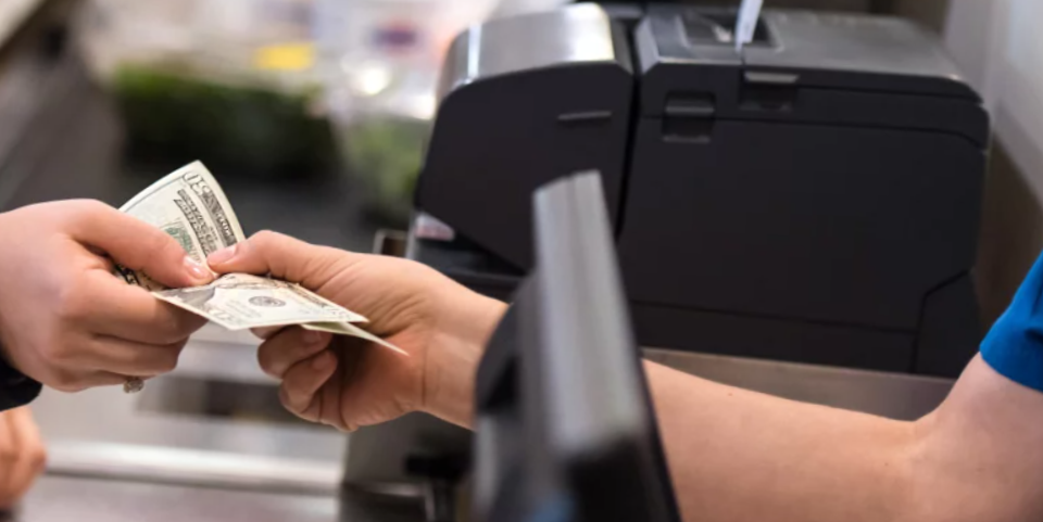 Walmart worker handing cash to customer