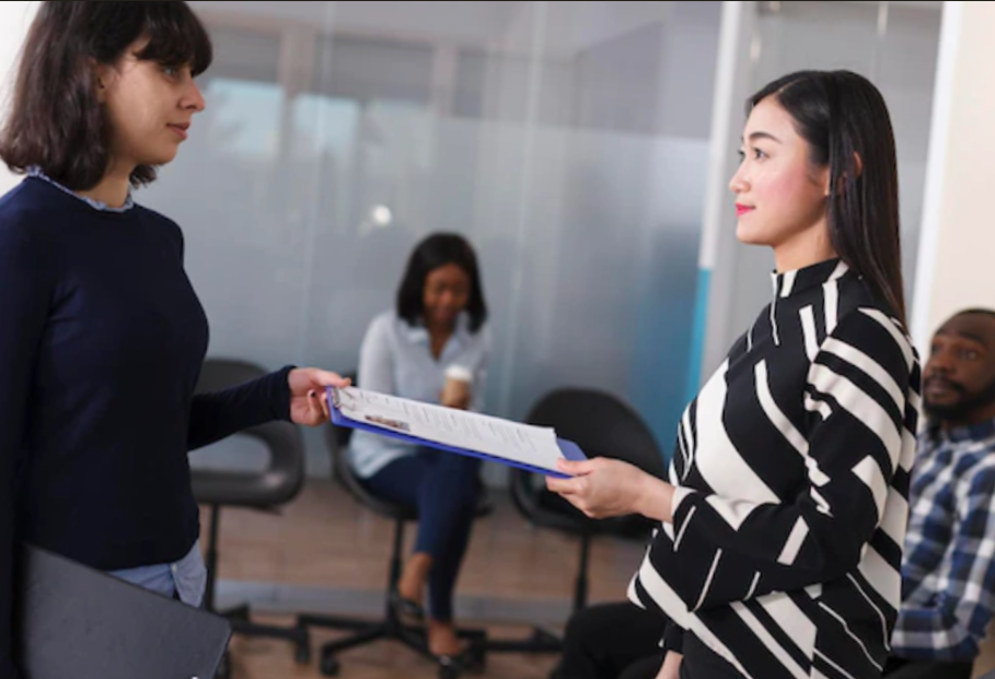young Asian woman giving cv resume to human resources manager